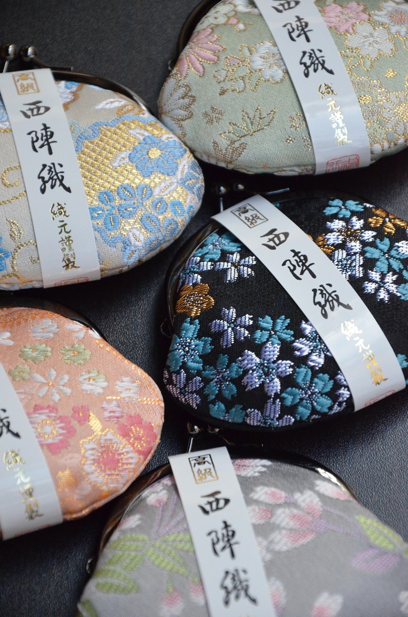 Portamonete artigianali giapponesi in tessuto Nishijin-ori con motivi floreali, realizzati a Kyoto – accessori tradizionali della Kyoto Selection disponibili su IKIYA.