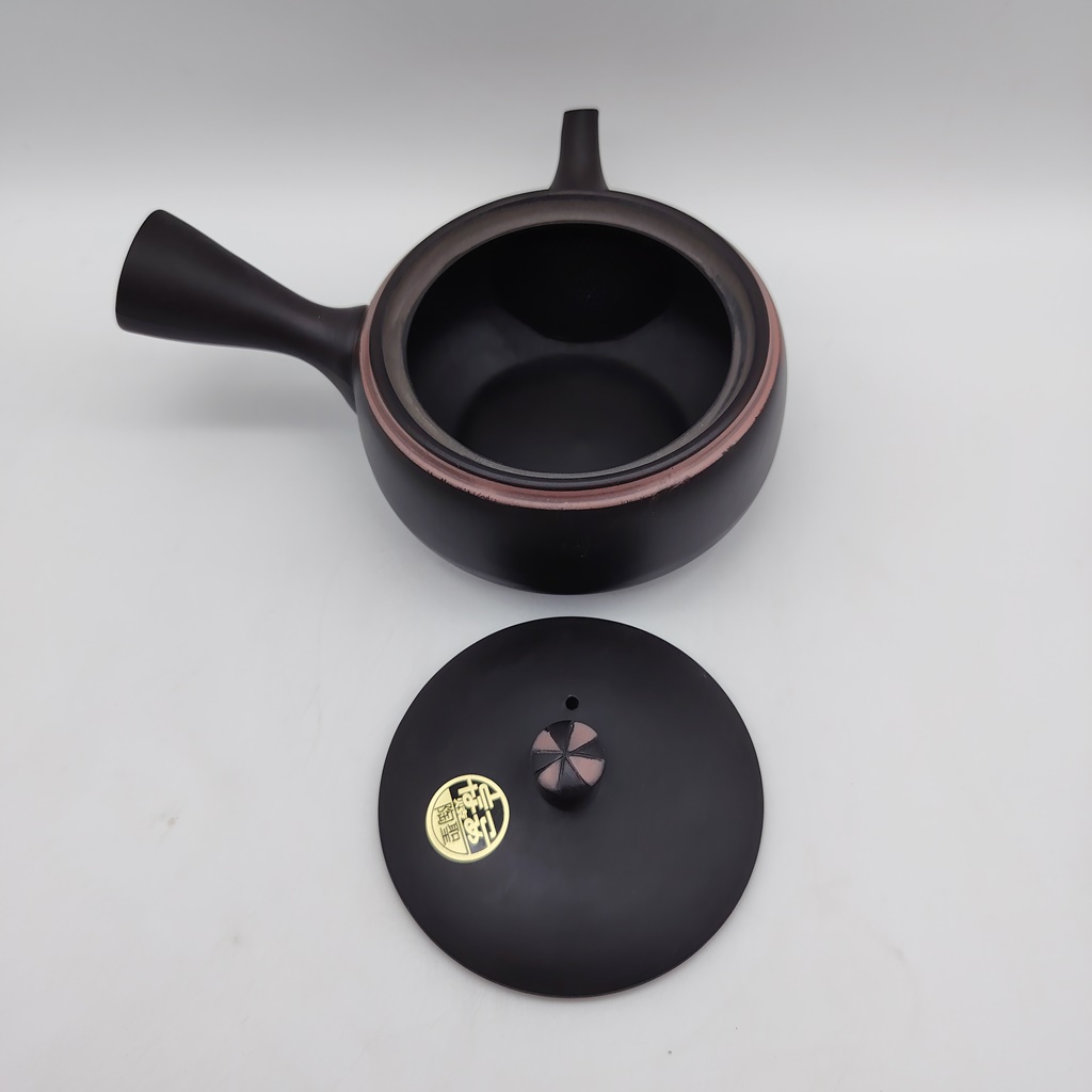 Kyusu in ceramica nera da 240ml con manico laterale, coperchio abbinato e bordo rosa. Sulla base del coperchio è visibile un sigillo dorato.