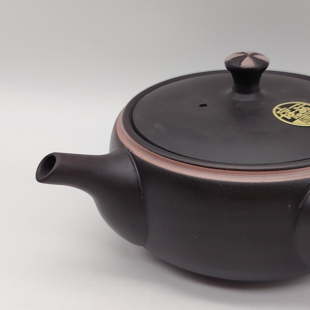 Kyusu in ceramica nera da 240ml con dettagli rosa e tappo decorato, su sfondo bianco.