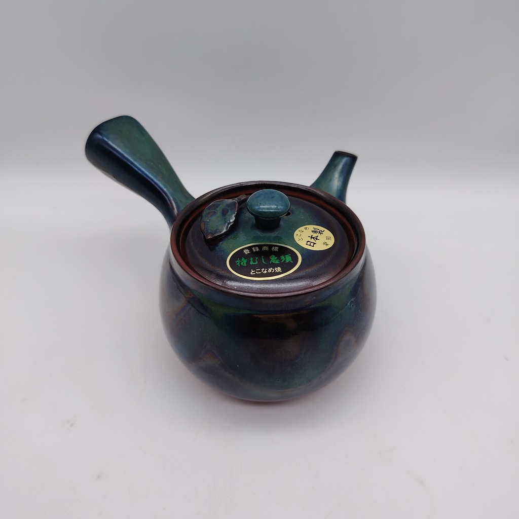 Kyusu in ceramica verde con dettagli iridescenti e un'elegante fogliolina sul coperchio, prodotto in Giappone.