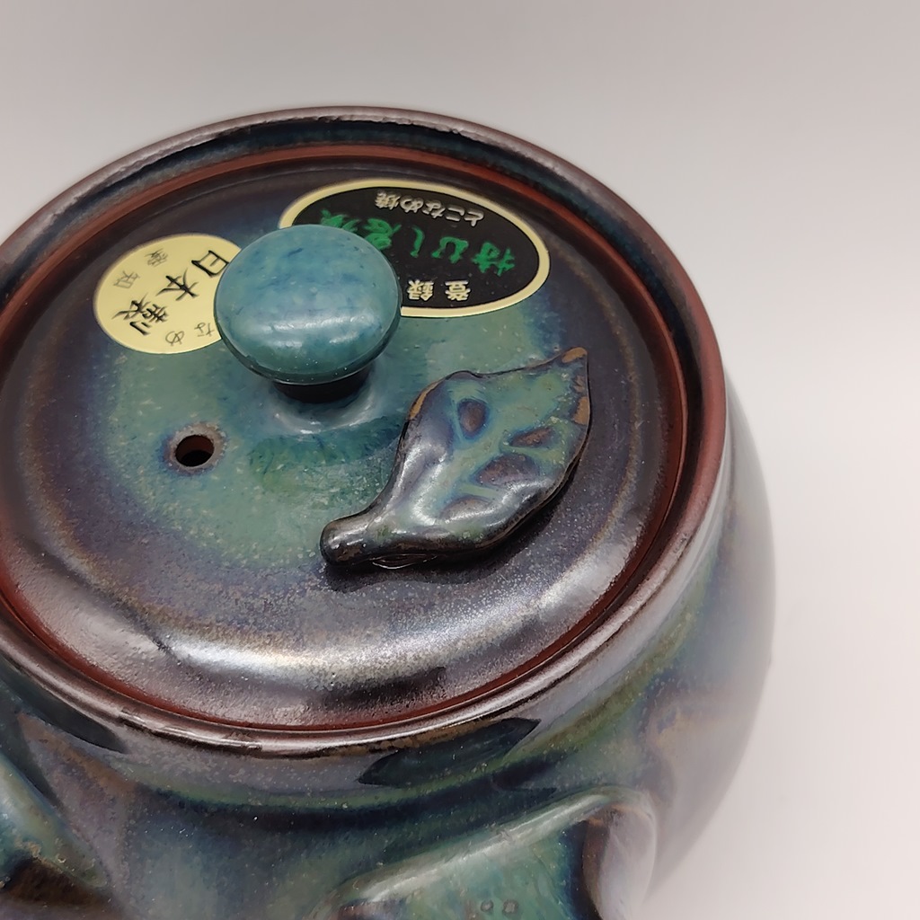 Kyusu in ceramica verde, 380ml, con coperchio e fogliolina decorativa, etichetta giapponese sul coperchio.
