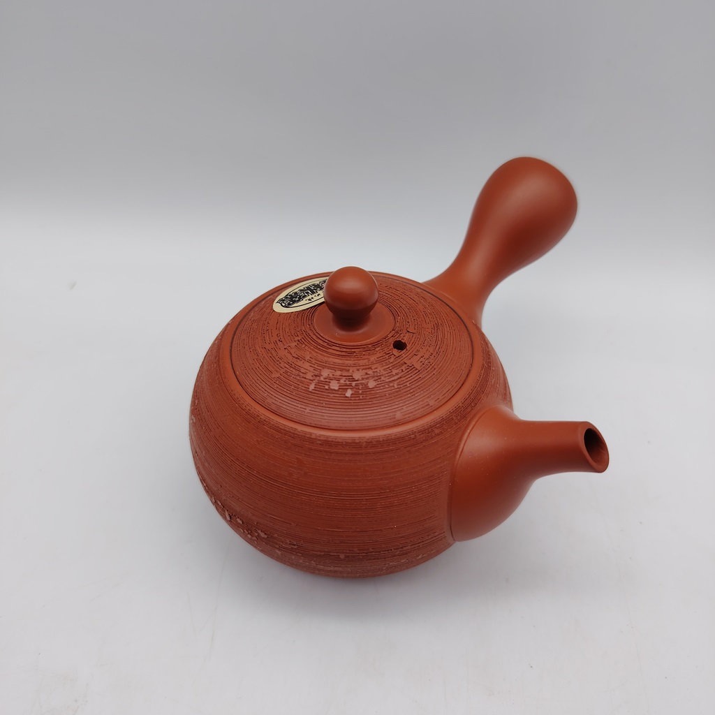 Kyusu rossa "matsukawa" da 180ml in terracotta, con finitura a righe e manico laterale, su sfondo bianco.