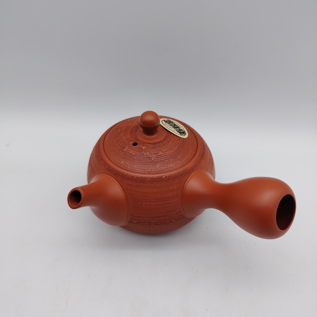 Kyusu rossa "matsukawa" da 180ml in terracotta con finitura testurizzata, coperchio e manico laterale distintivo, su sfondo bianco.