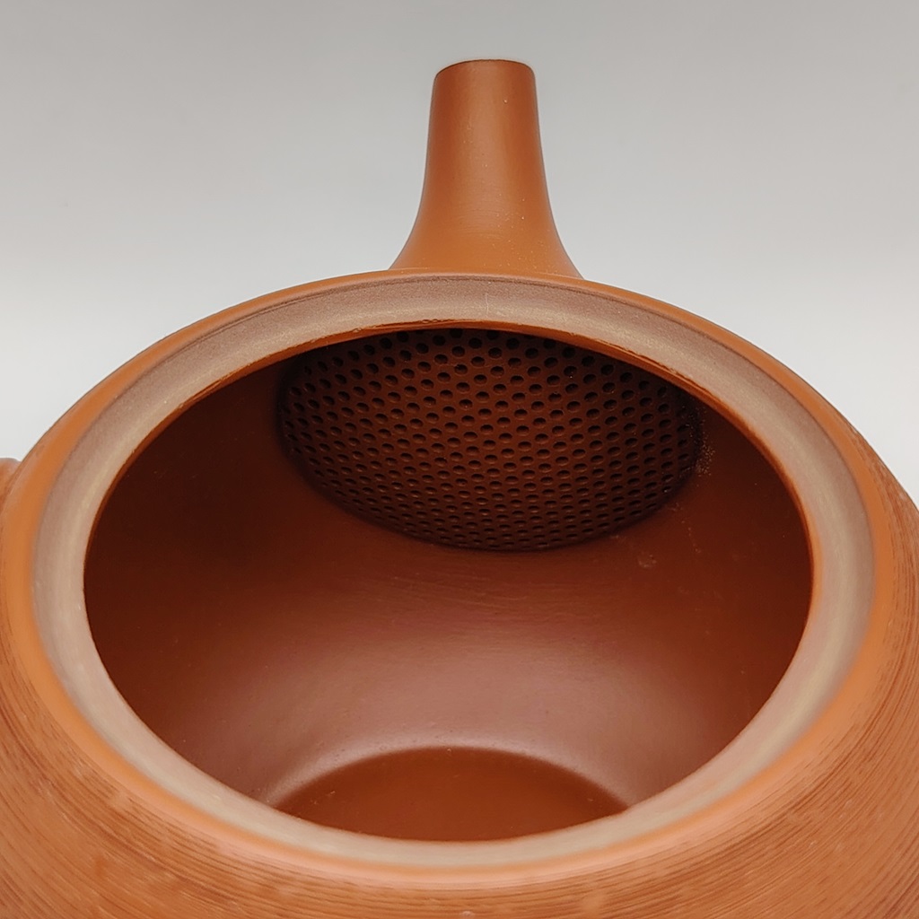 Interno di una kyusu rossa "matsukawa" da 180ml, con un filtro a rete finemente forato per il tè.