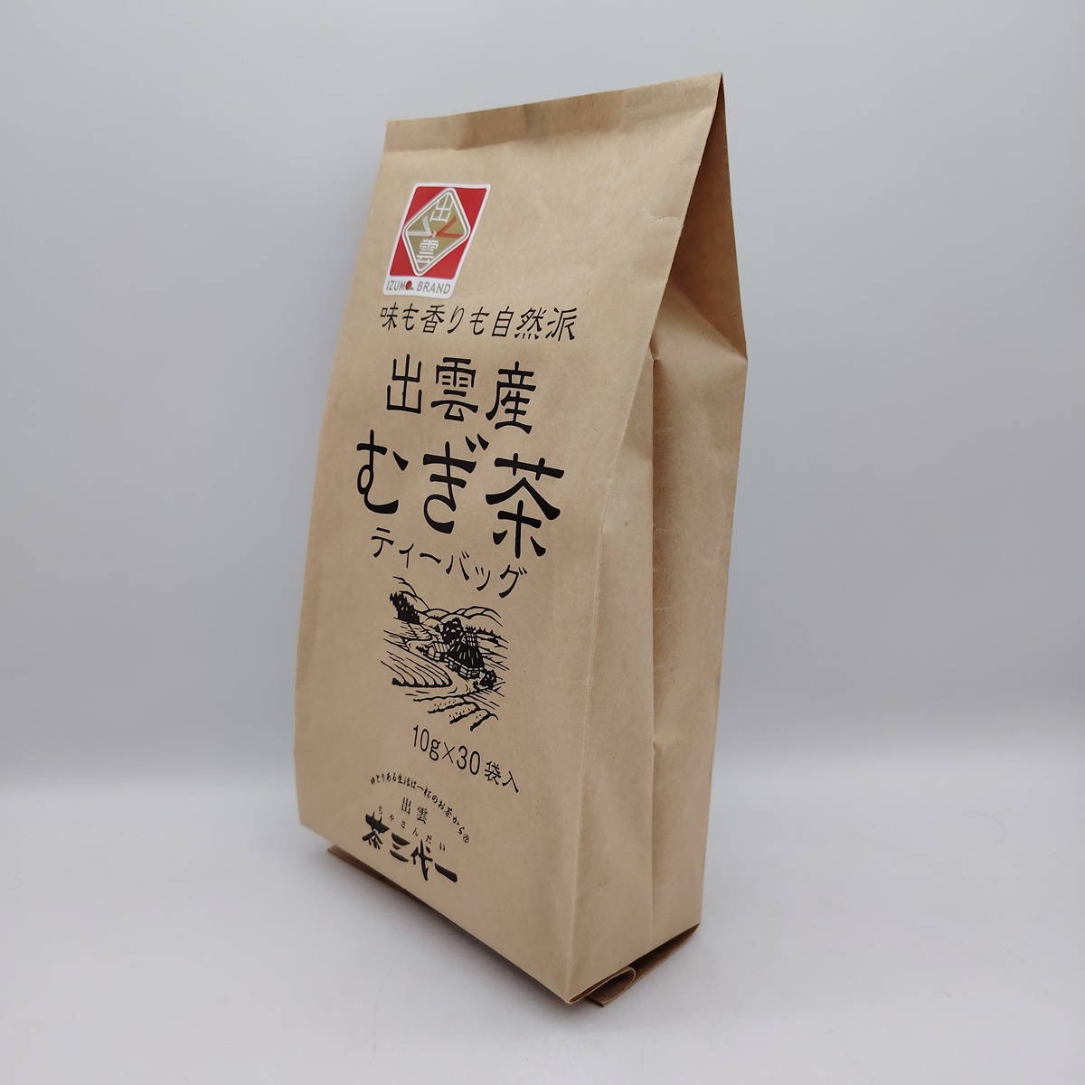 Bag of Japanese barley tea (mugicha) from the Izumi brand, with Japanese writing and an illustration of a rural landscape.