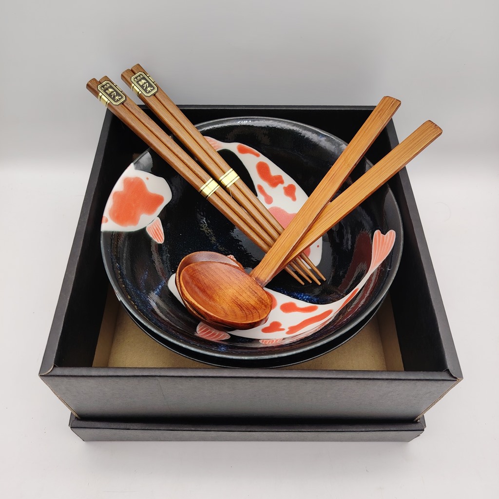 Set di due ciotole da ramen in ceramica nera decorate con carpe koi arancioni e bianche, completo di bacchette e cucchiaio di legno, presentato in una scatola nera.