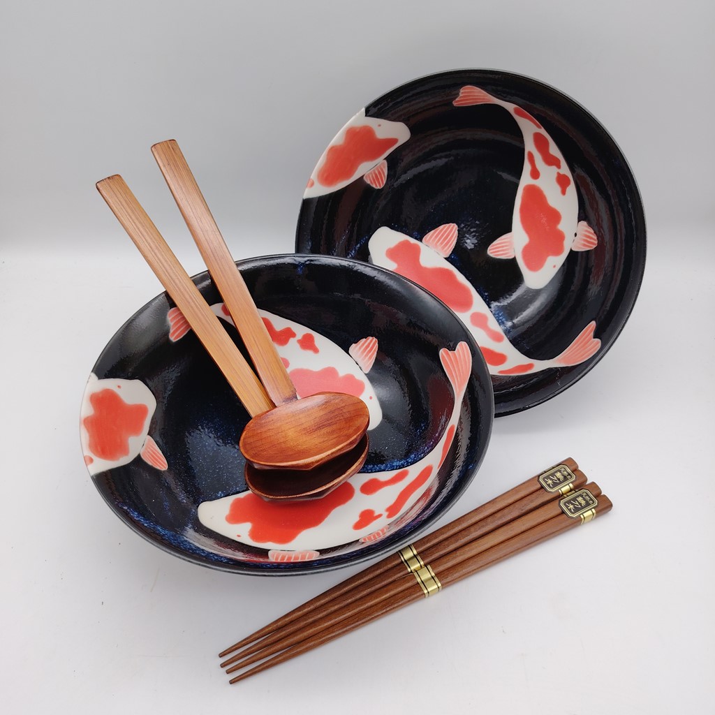 Set di due ciotole da ramen con carpe koi decorate in bianco e rosso su sfondo nero, accompagnate da bacchette in legno con scritte dorate.