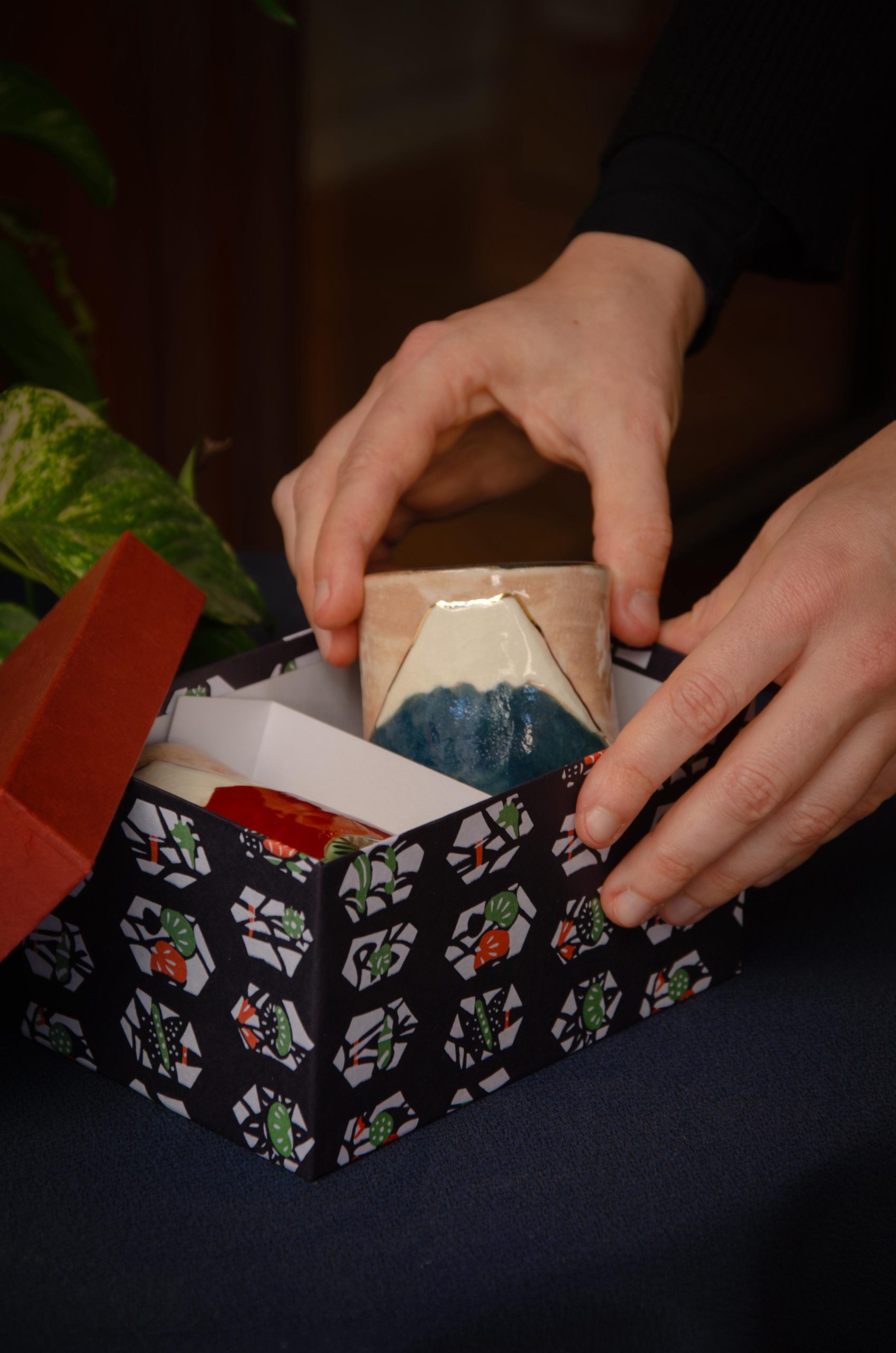 Kyoto ceramics, in collaboration with Kyoto Prefecture People holding a ceramic vase depicting a Japanese mountain, with a box decorated with Japanese motifs.