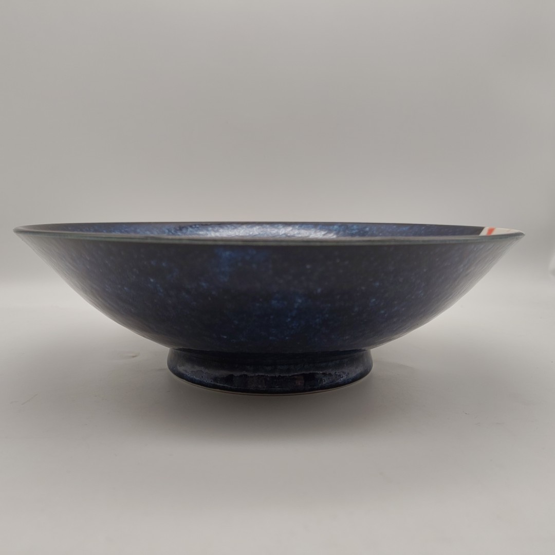Primo piano di una ciotola da ramen blu scuro con un motivo di carpe koi bianche e arancioni in rilievo, 25x7,5 cm.