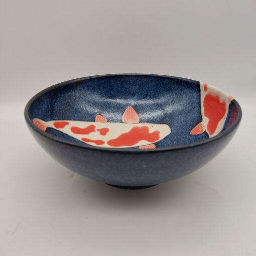 Ramen bowl with white and red koi fish decoration on a blue background, 21.5 cm diameter.